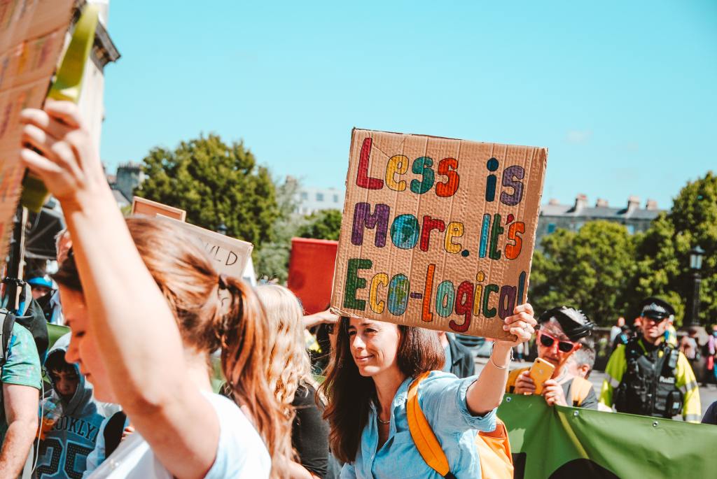 less is more ecological protest for environment in san francisco california people holding up signs outside 
