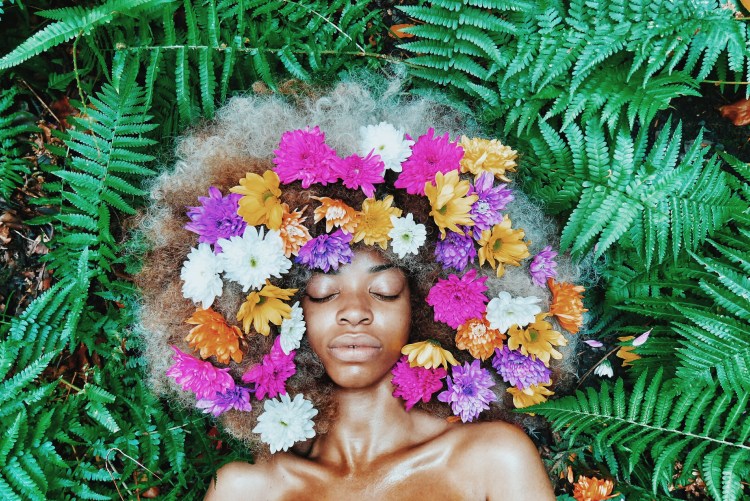 black woman with flowers in hair vsco in grass in peace