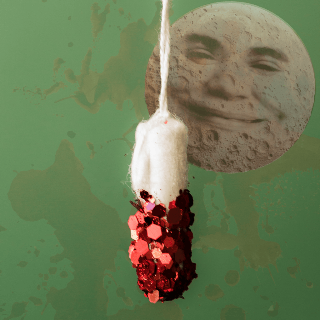 A hanging decorative object made of white cotton topped with red sequins, set against a green background featuring a large, smiling moon.